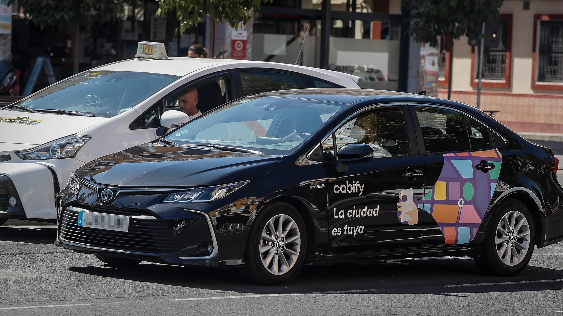 Un taxi y un vehículo de Cabify en Sevilla